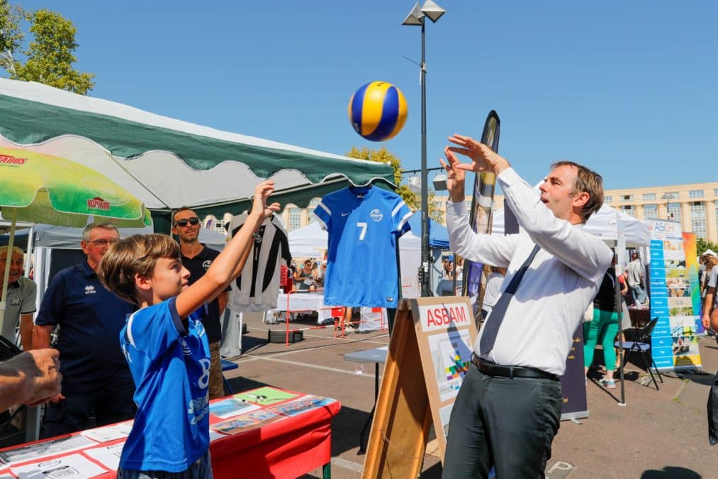 Stand ASBAM Montpellier Volleyball à la Foire aux associations, échange de ballon entre un jeune licencié et un membre du club